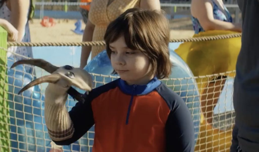 A screenshot from Little Evil- See the Krampus puppet on the kid's hand?-Best Christmas Horror Movies 2020